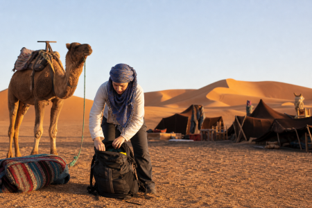 Best Time to Visit Merzouga by month with a traveler beside Erg Chebbi dunes